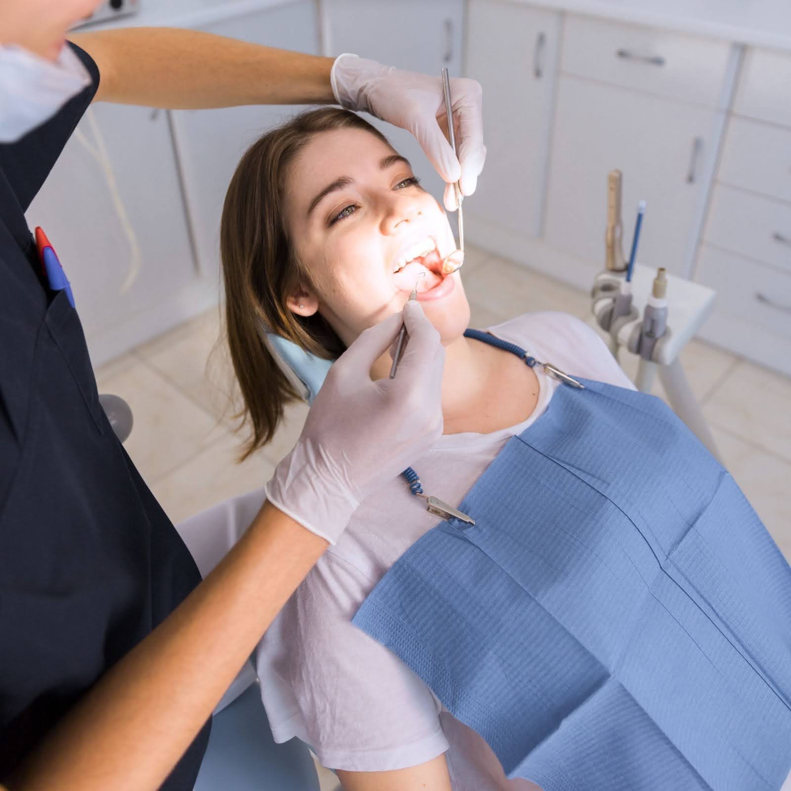 Orthodontic assistant checking a patient’s braces in the chair